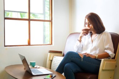Beyaz gömlekli geç café'de rahatlamak için sıcak çikolata içme yaratıcı kadın.