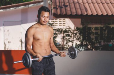 Egzersiz için barbell kullanan adam.