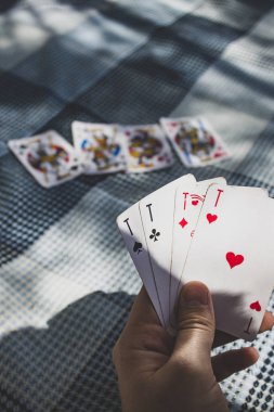 Kart oyunu açık havada, oyuncunun elinde dört as (Sukoan plaj, Hırvatistan)