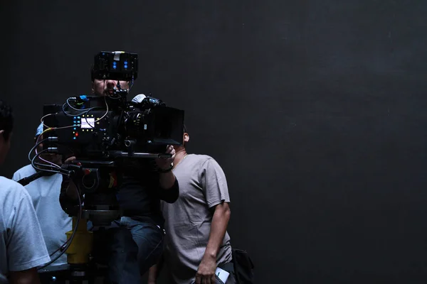 a cameraman with his team working in studio for shooting a movie