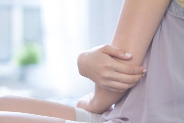 nemlendirici krem uygulanırken genç kadın dirsek yakın çekim