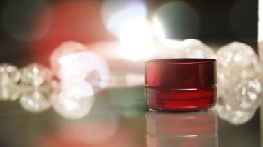 kırmızı bir Kozmetik şişe ve parlak şeyler arka planda oldu stüdyoda çekim için kurulum