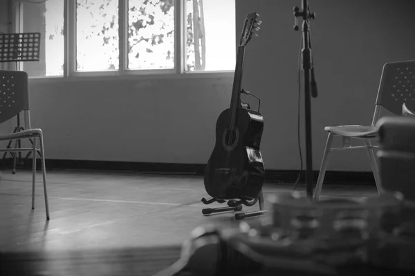 Guitare acoustique debout dans une pièce vide — Photo