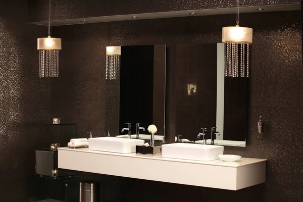 Beyaz banyo tezgahı ve altın parıltılı duvar