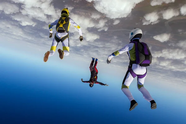 跳伞照片三个跳伞运动员在自由落体中形成了一个人形 极端体育概念 — 图库照片