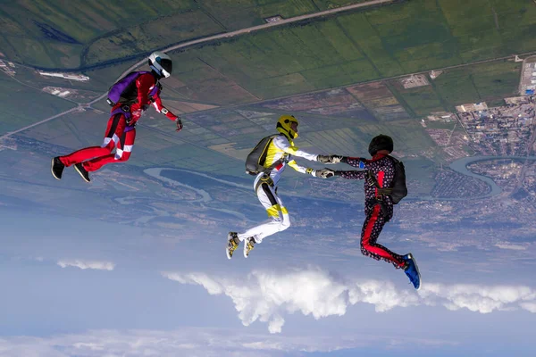 跳伞照片三个跳伞运动员在自由落体中形成了一个人形 极端体育概念 — 图库照片