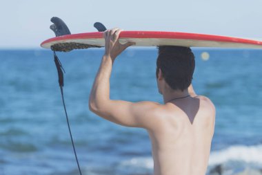 yakışıklı sörfçü kafasına Surfboard holding