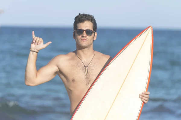 Shaka el işareti yapıyor surfboard holding sörfçü adam