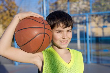 Kolsuz bir sarı giyen sahada ayakta genç basketbolcu