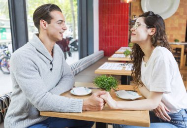 Genç çift küçük tablo bir kafede oturup.