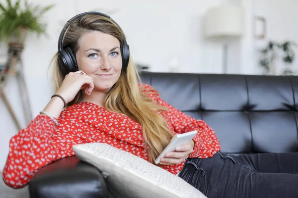 Mujer Feliz Escuchando Música Usando Auriculares Mirando Cámara Sentada Sofá — Foto de Stock