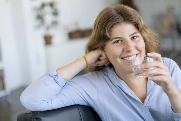 Chica Bebiendo Agua Sentada Sofá Casa Mirando Cámara — Foto de Stock