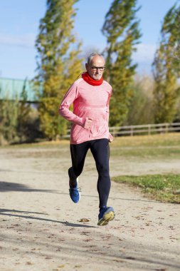 Üst düzey bir adam siyah giyimli ve yeşil parkta çalışıyor