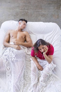 Bir sorunumuz var. Genç kız yatakta yatarken erkek karşı yatağın kenarında oturan üzgün.