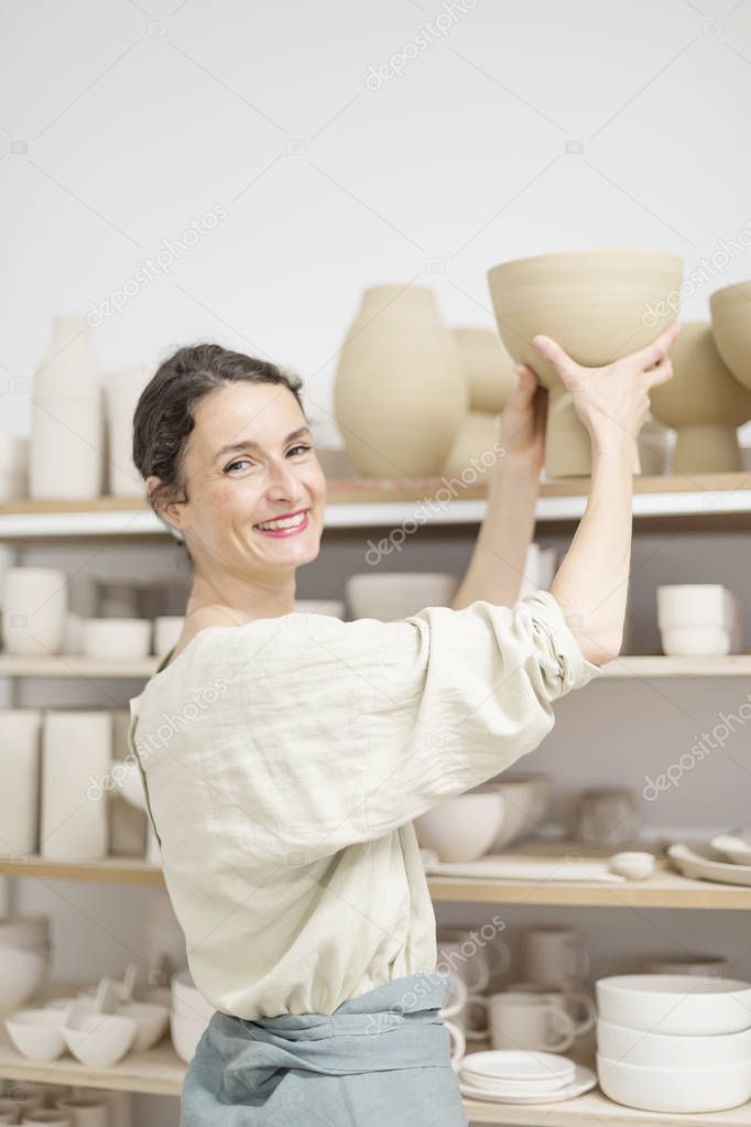 Beautiful ceramist owner looking to the camera while smiling