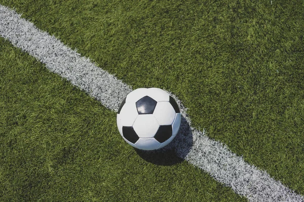 Vintage soccer ball on green grass over the white line