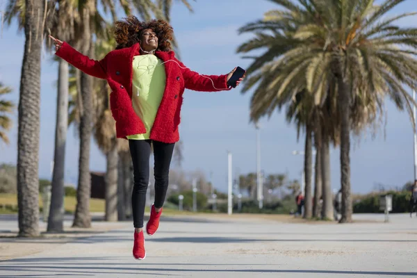 Vista Frontal Una Joven Hermosa Rizada Afroamericana Saltando Bailando Mientras — Foto de Stock