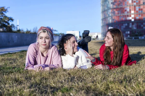 Tři přítelkyně, které na podzim leží na trávě v parku — Stock fotografie