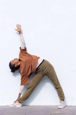 Şık çekici genç kadın atlet içinde ısınma rutin açık havada duvara çalıştırmadan önce yapıyor siyah spor giyim