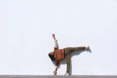 Şık çekici genç kadın atlet içinde ısınma rutin açık havada duvara çalıştırmadan önce yapıyor siyah spor giyim