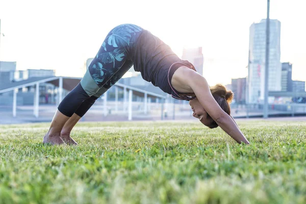 Vacker kvinna gör yogaövningar i parken — Stockfoto