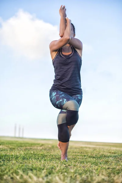 Parkta yoga egzersizi yapan güzel bir kadın. — Stok fotoğraf