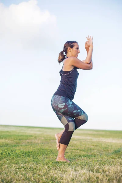 Vacker kvinna gör yogaövningar i parken — Stockfoto