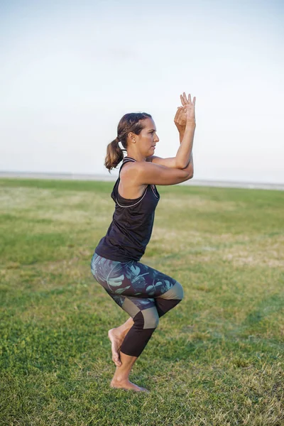 Parkta yoga egzersizi yapan güzel bir kadın. — Stok fotoğraf