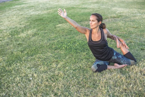 Parkta yoga egzersizi yapan güzel bir kadın. — Stok fotoğraf