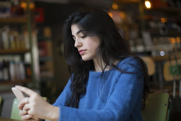 Junge Frau in Freizeitkleidung unterhält sich im Café per Video-Chat mit ihrem Smartphone — Stockfoto