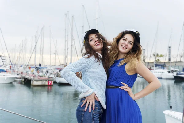 Mooie vrouwen, brunette met lang recht haar, schattige glimlach in een haven op de achtergrond van boten en jachten — Stockfoto