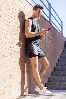 Akıllı telefondan spor sonuçlarını kontrol eden genç bir adamın portresi