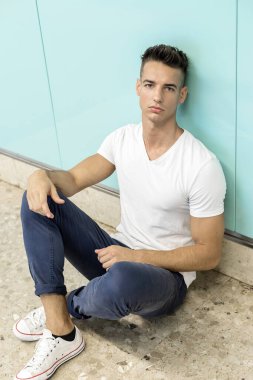 Depresyondaki genç adam zemin sokak metrosunda oturuyor.