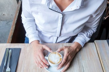 Kafede kahve içen genç sarışın kız.