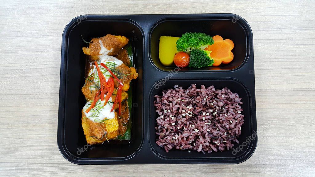 Lunch box with rice berry, vegetables and chicken.