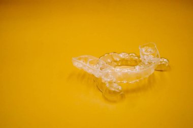 Turuncu arka plan üzerinde diş düzenleme ameliyatı için invisalign tutucu