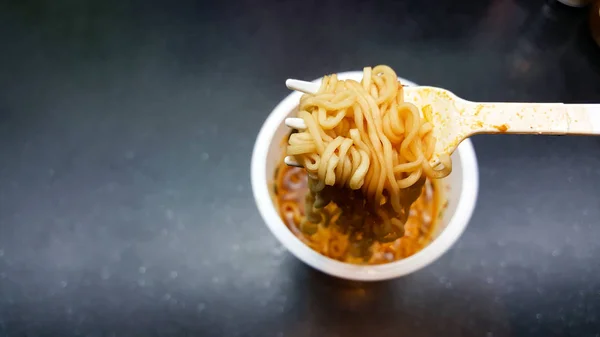 Alguien está sosteniendo tenedor plástico para comer fideos instantáneos de la — Foto de Stock