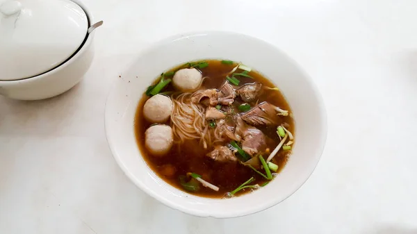 Comida de macarrão de carne oriental chinesa em tigela branca e mesa branca — Fotografia de Stock