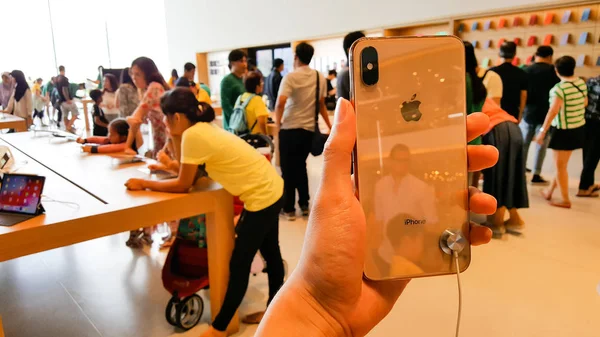 Руки на новый Apple iPhone XS Max в Apple Store — стоковое фото