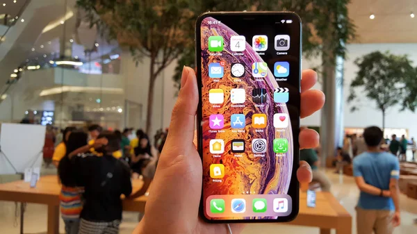 The new Apple iPhone XS Max is displayed with home screen and price list on hand — Stock Photo, Image