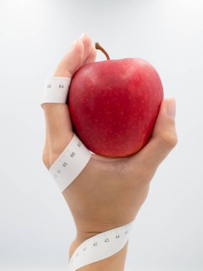 Adamın eli taze kırmızı elma tutan bu spiral kol ve el