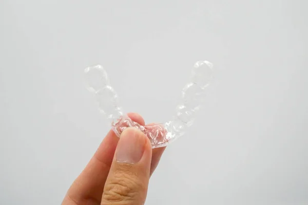 Hand on clear plastic retainer teeth in the box set — Stock Photo, Image