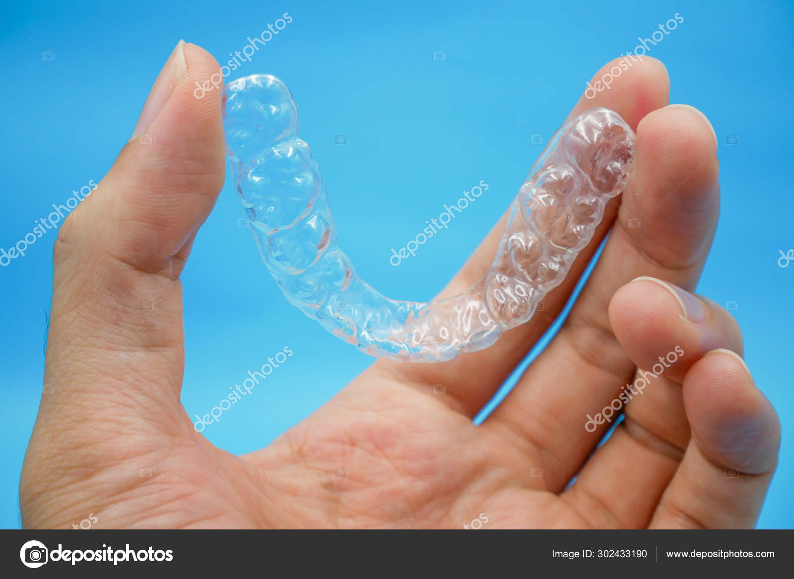 Hand holding clear plastic retainer teeth Stock Photo by ©Bhubeth