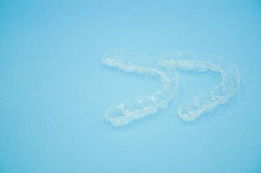 el mavi arka plan üzerinde izole net plastik tutucu dişleri tutarak