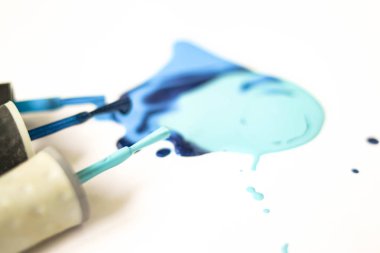 Püsküller damladamla ile Mavi oje shellac vernik leke beyaz arka plan üzerinde yakın damla.