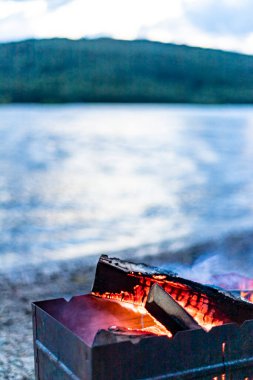 Brezilya mangalı, yanan odun, duman, nehir kıyısında sıcak ateş, doğal arka plan..