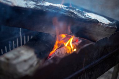 Brezilya mangalı, yanan odun, duman, nehir kıyısında sıcak ateş, doğal arka plan.