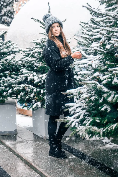 Beautiful russian girl in a cloud day in winter style clothes, walking in Tverskaya Square in Christmas time