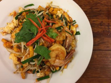 Tayland usulü kızarmış şehriye (pad Thai), bu sokak yemeği ve Bangkok, Tayland 'ın en ünlüsü, ahşap bir masada siyah bir tabakta lezzetli ve güzel olmak isteyen açlığa neden oluyor.