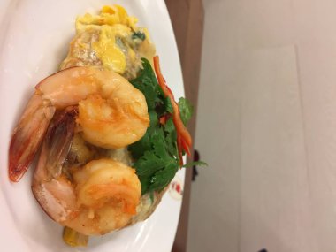 Tayland usulü kızarmış şehriye (pad Thai), bu sokak yemeği ve Bangkok, Tayland 'ın en ünlüsü, ahşap bir masada siyah bir tabakta lezzetli ve güzel olmak isteyen açlığa neden oluyor.